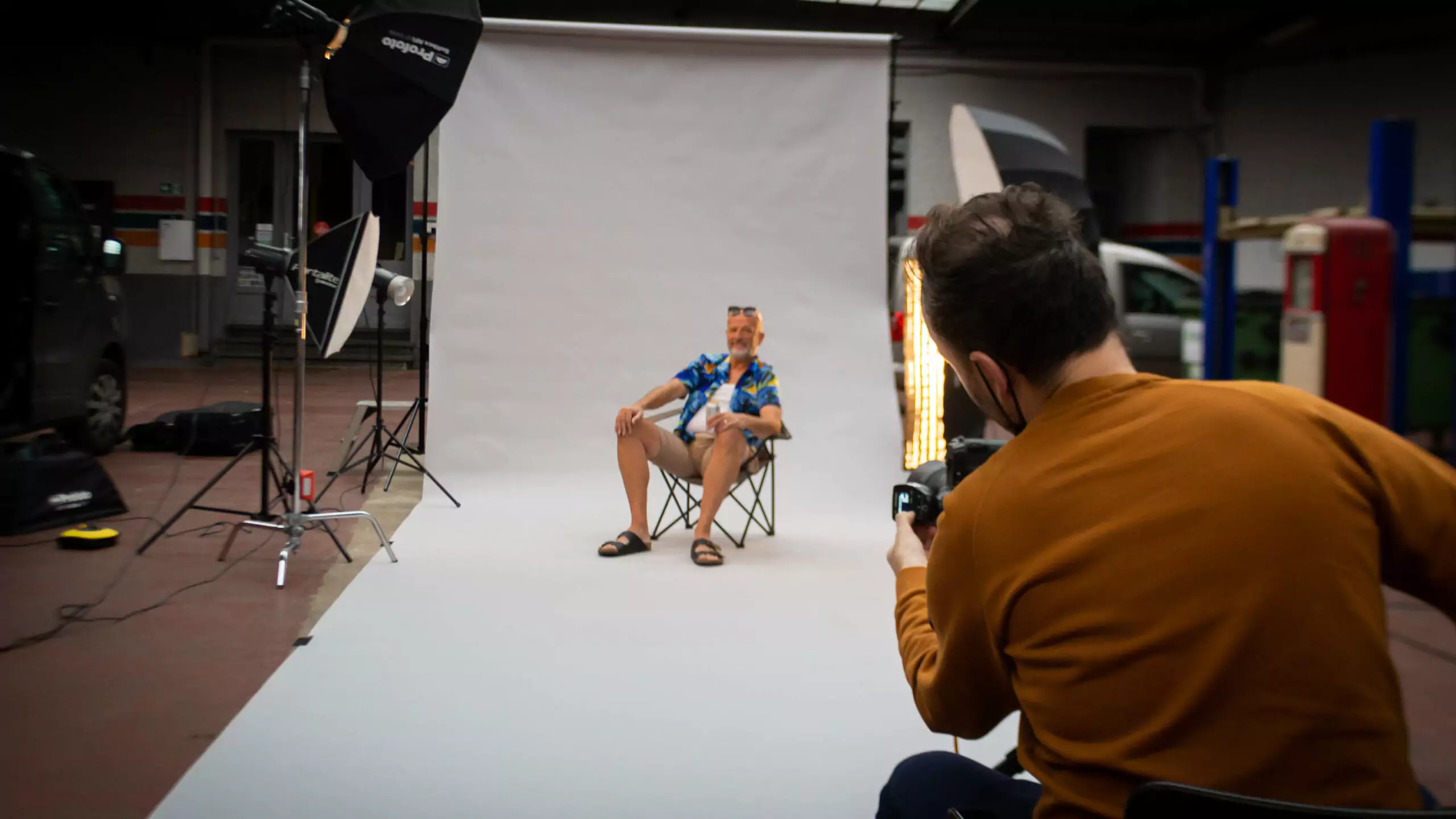 De acteur zit in zijn kampeerstoel met een pintje bier en poseert voor de fotograaf