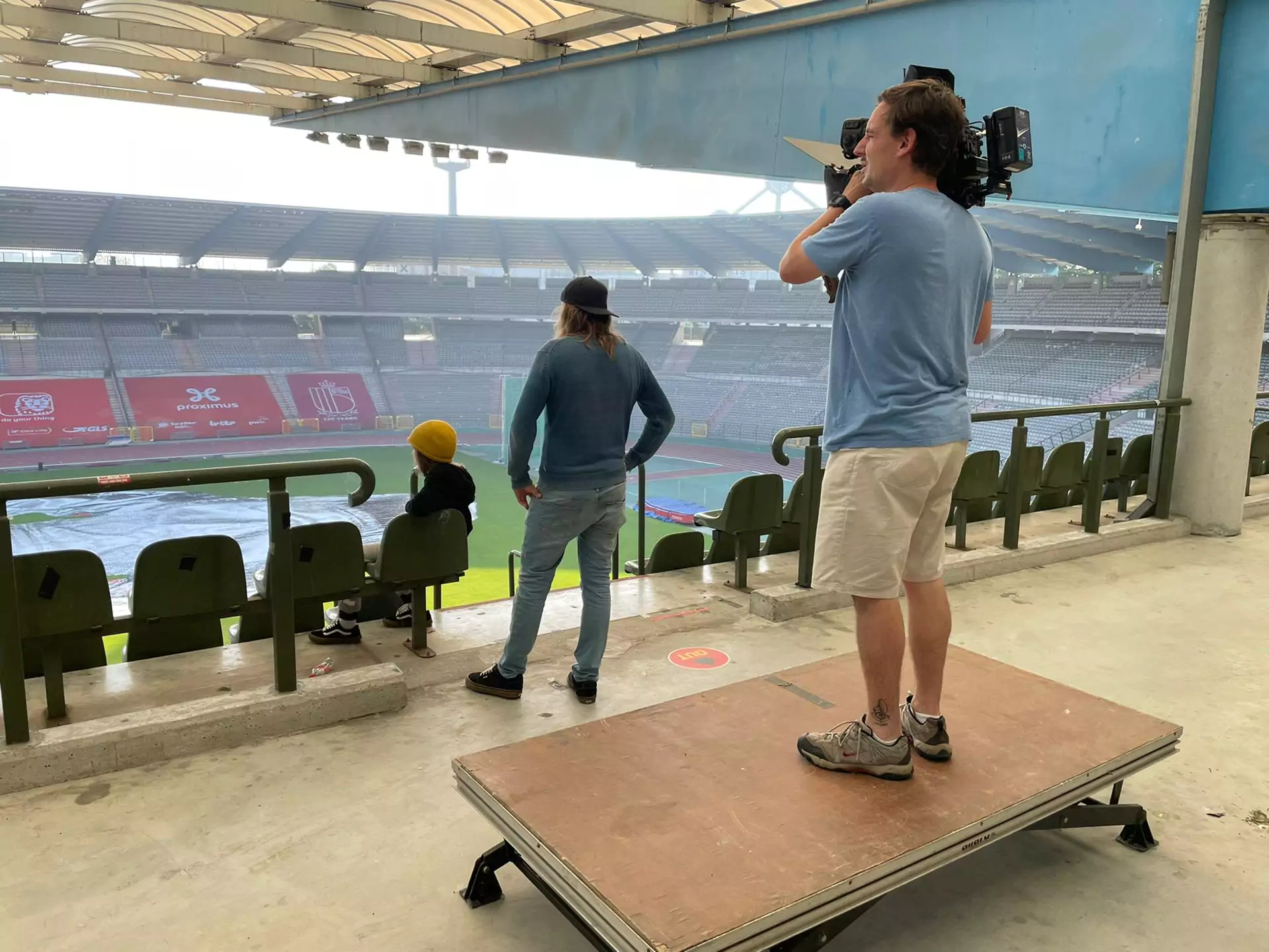 De cameraman staat op een verhoogd podium en neemt beelden van het stadion