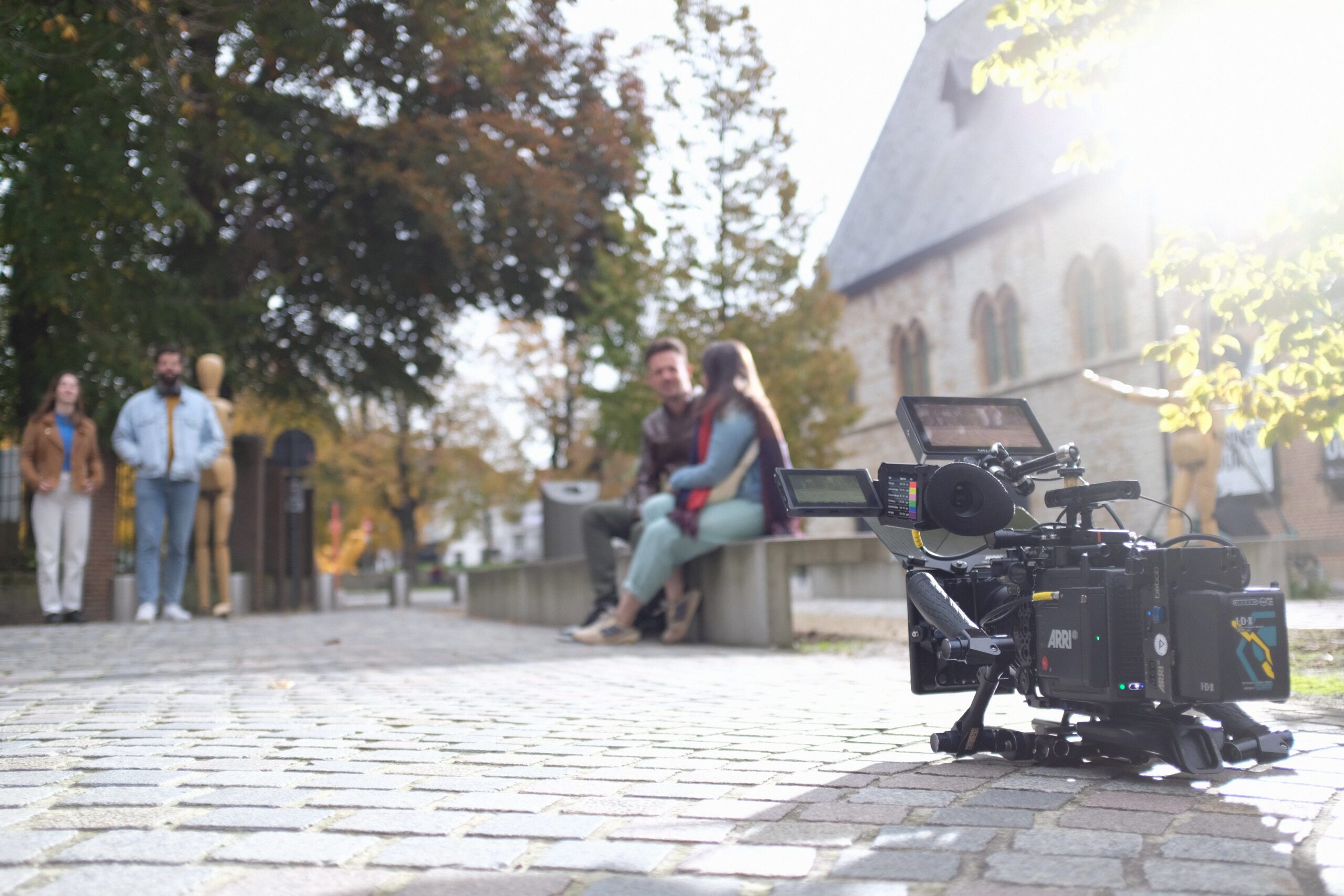 De camera staat op de grond en filmt de figuranten